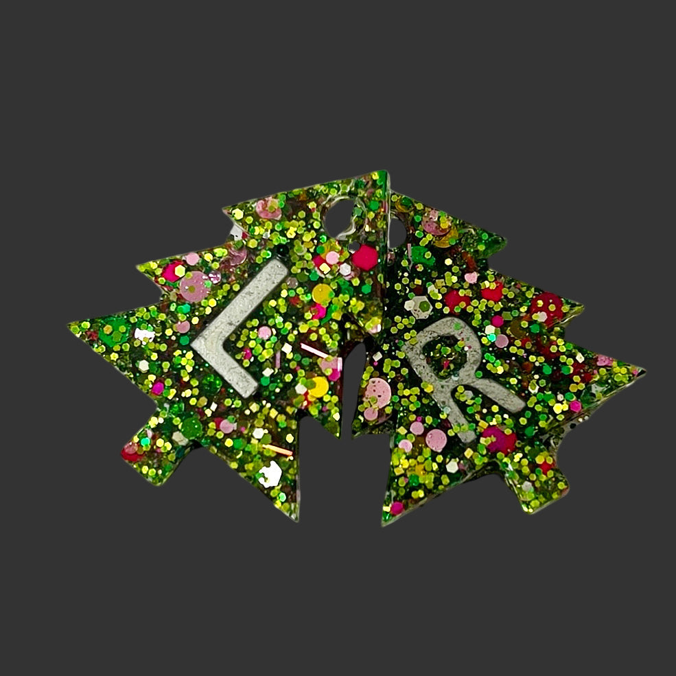 Assorted novelty radiology X-ray markers with playful themed designs such as ghosts, unicorns, hearts, scrubs, and alien faces.