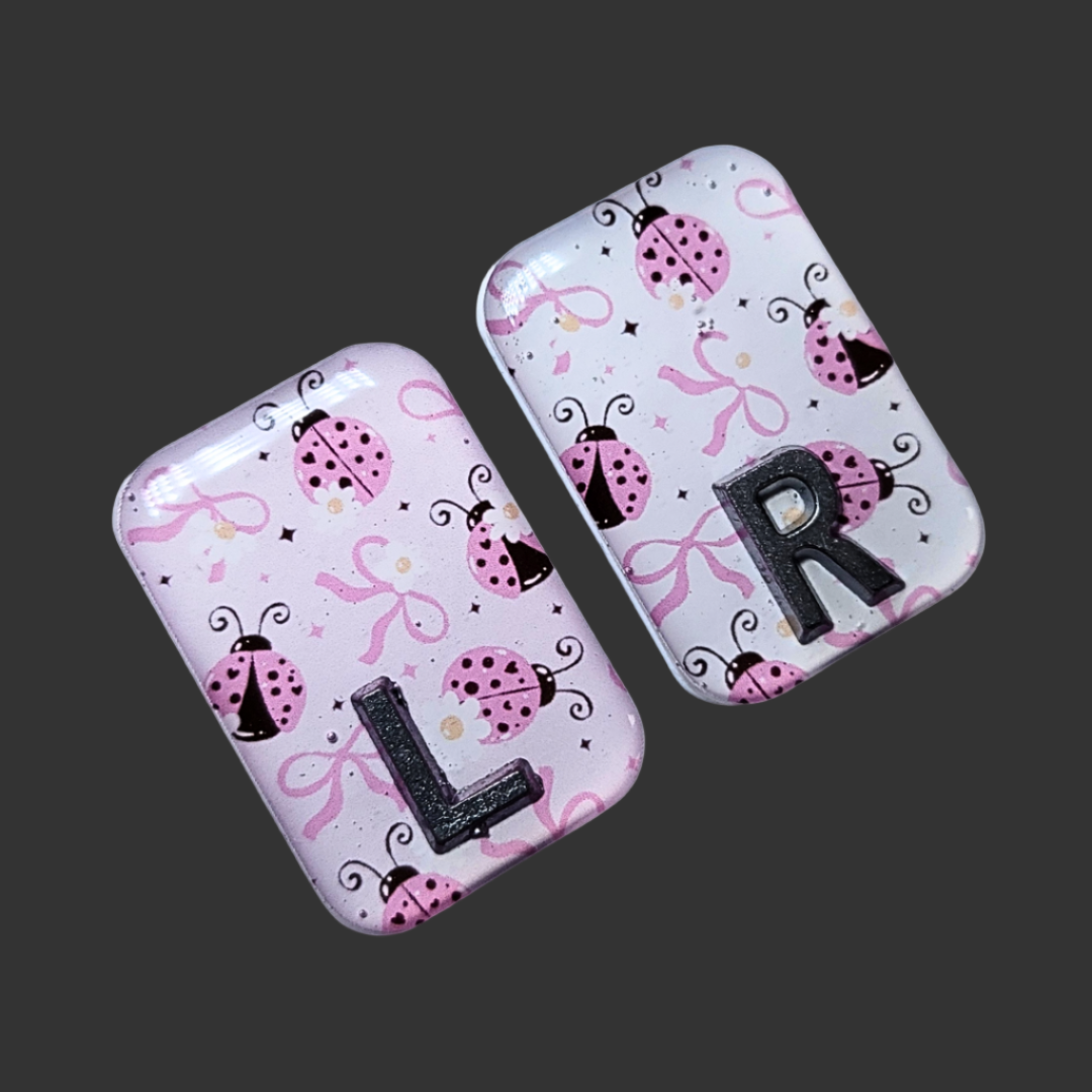 Pink, black, and white ladybug-themed X-ray marker with customizable initials