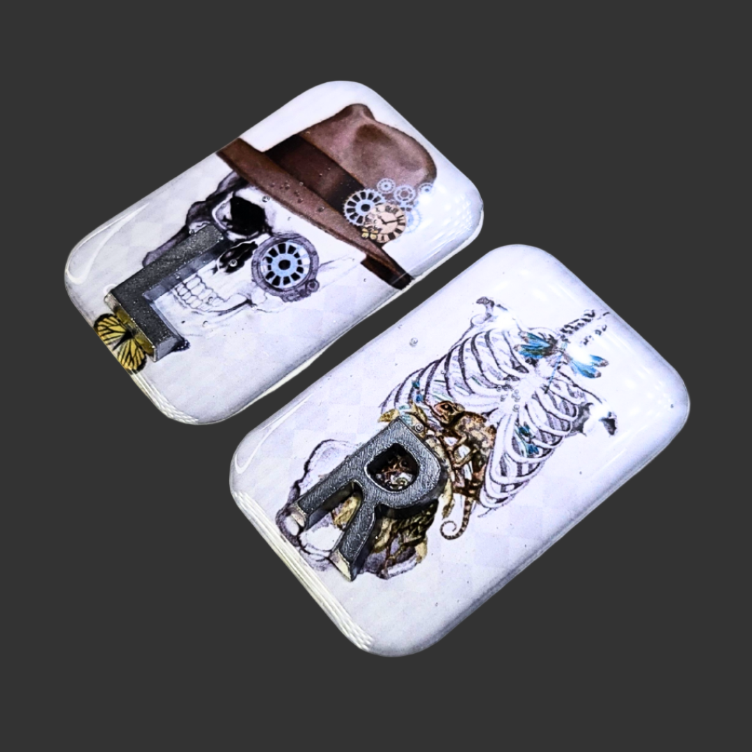 Handmade X-ray markers featuring a skull with hat left marker and thorax/pelvis anatomy right marker, personalised with initials