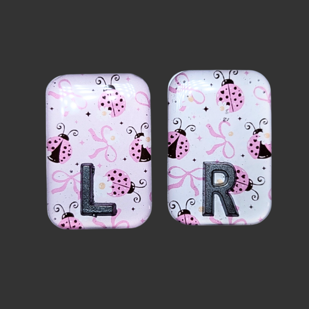 Pink, black, and white ladybug-themed X-ray marker with customizable initials