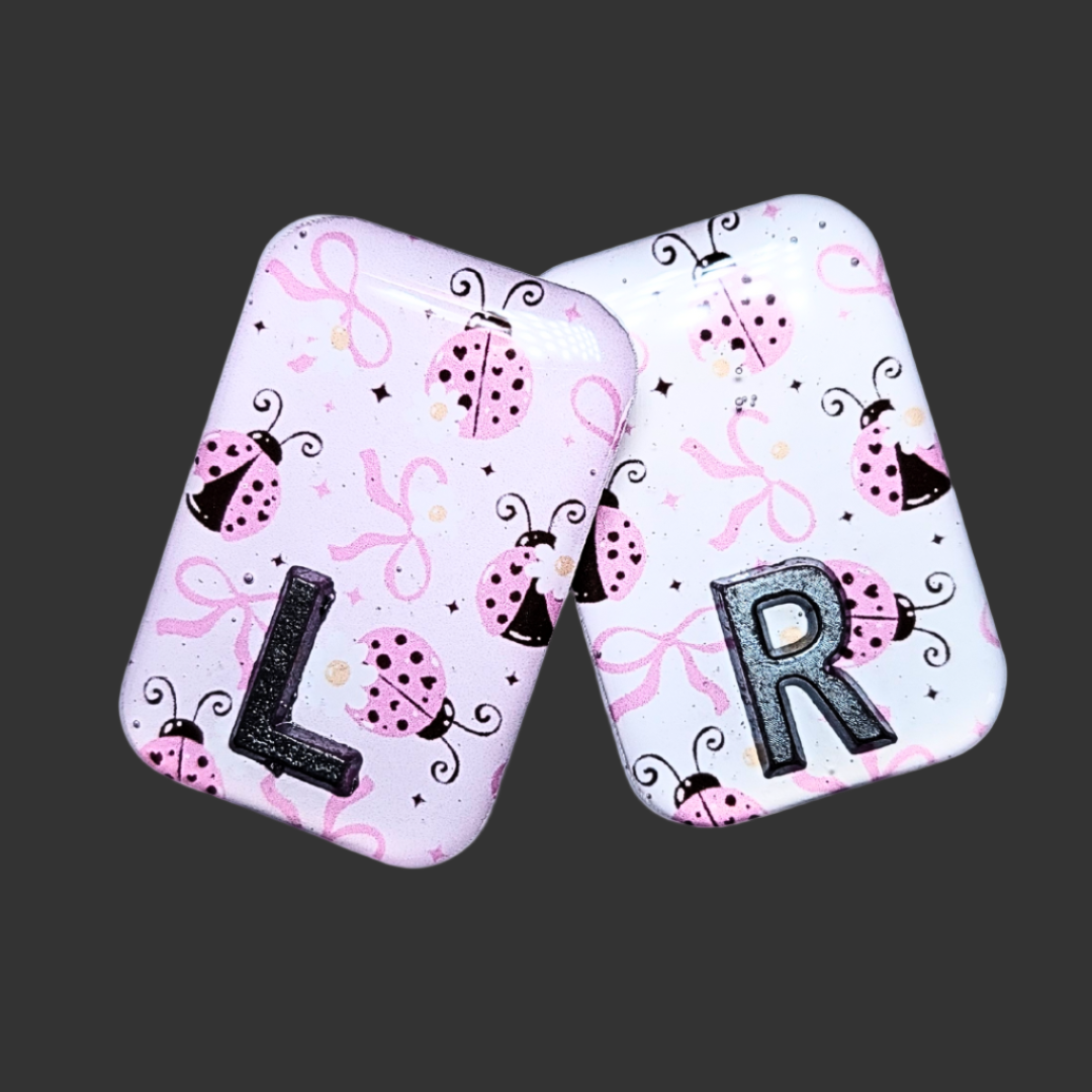 Pink, black, and white ladybug-themed X-ray marker with customizable initials