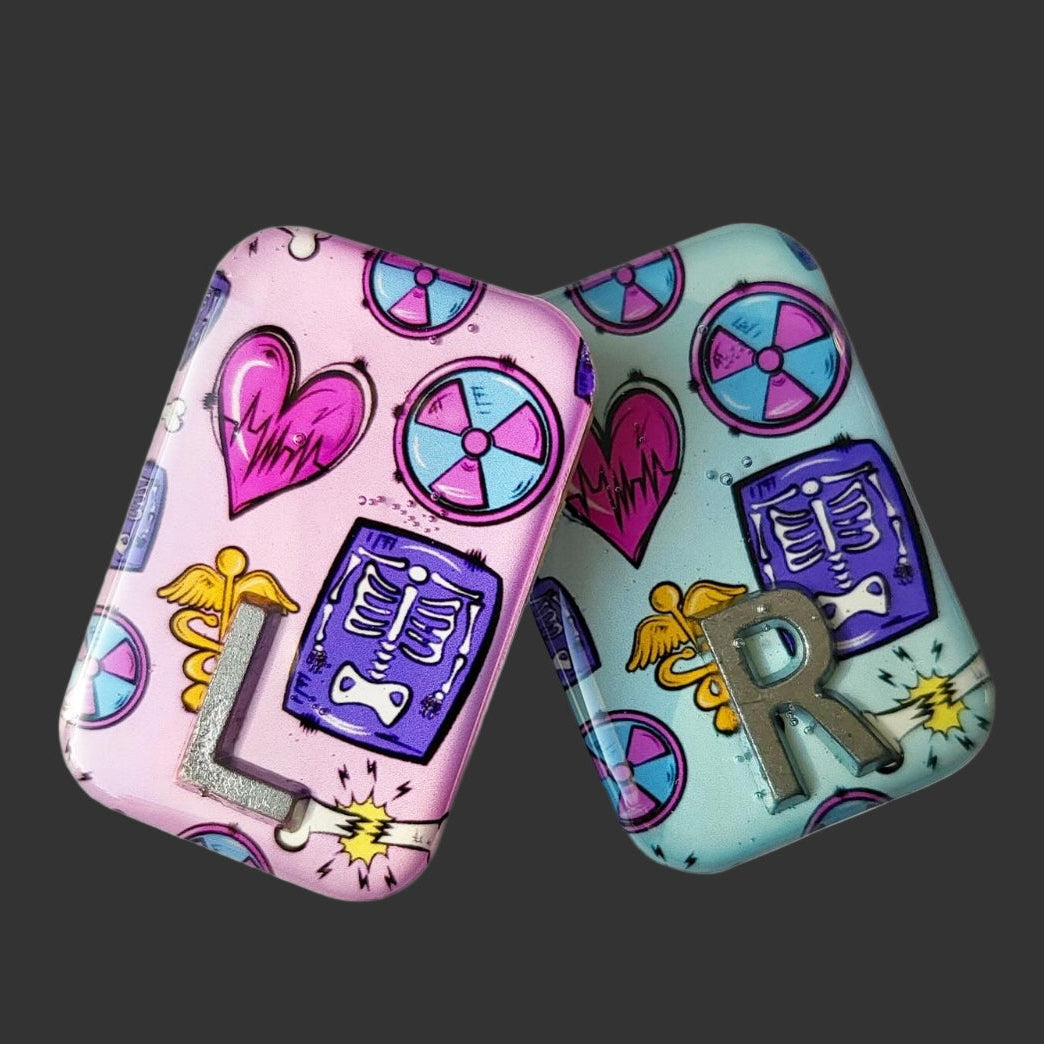 X RAY MARKERS THAT ARE PINK AND TEAL WITH X RAY SYMBOLS ON, RADIOGRAPHER AND X RAY TECH MARKERS