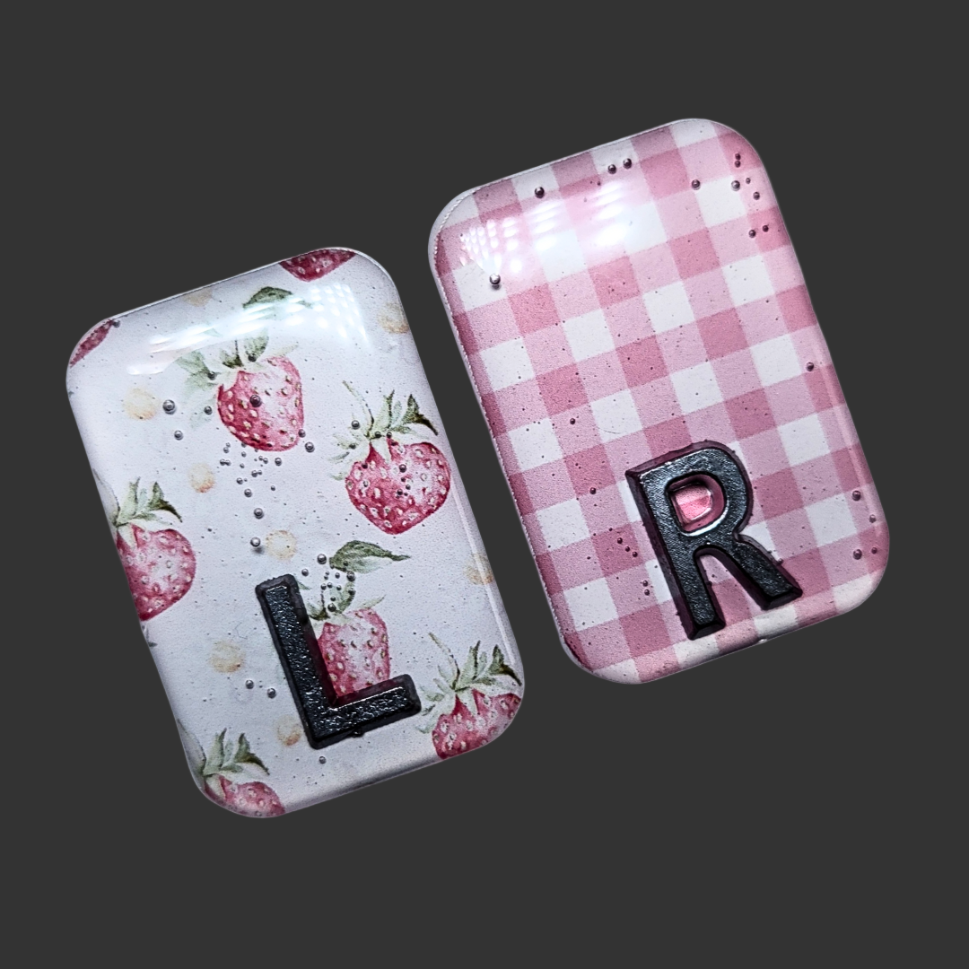 Strawberry-themed X-ray markers with a pink and white checked pattern and custom initial