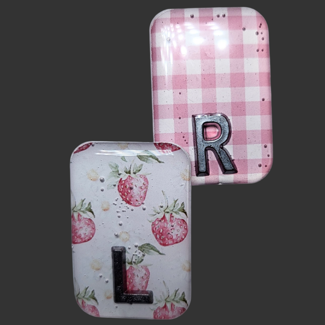 Strawberry-themed X-ray markers with a pink and white checked pattern and custom initial